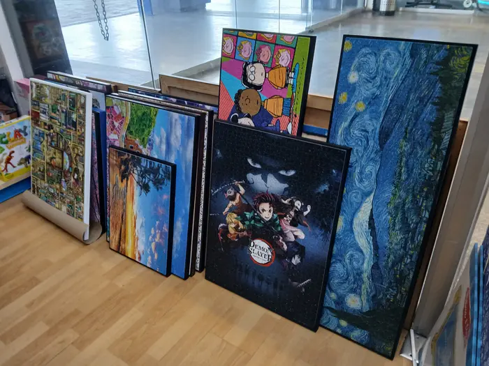 Varios rompecabezas terminados y montados sin marco, en exhibición